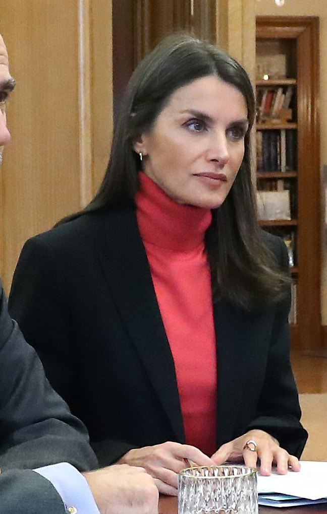 Queen Letizia wore a black pant suit contrasted with a coral rollneck top, and accessorized with small hoop earrings. 