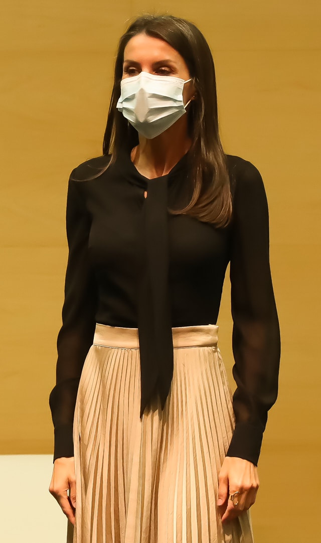 Queen Letizia wears a Black tie blouse with metal buttons and sheer long sleeves